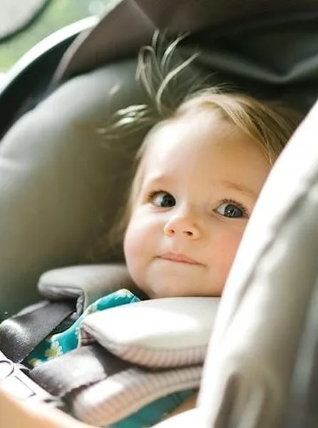 Infant securely fastened in a car seat, demonstrating proper child car seats California safety guidelines.